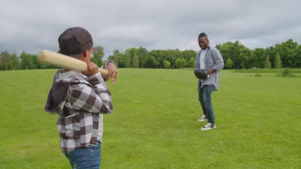 Actieve zwarte familie spelen honkbal spel op groen veld — Stockvideo