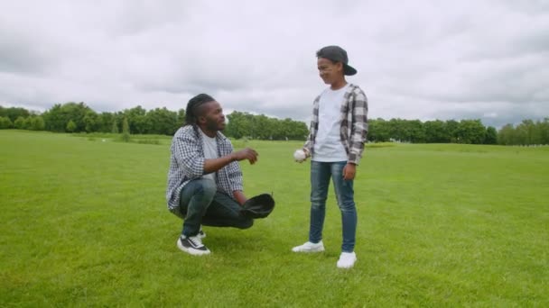 Cuidando do pai africano e do filho pequeno conversando antes do treinamento de beisebol — Vídeo de Stock