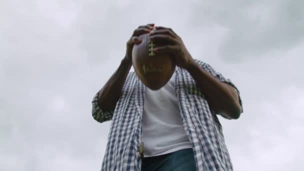 Jugador de fútbol americano negro lanzando pelota en el campo verde — Vídeos de Stock