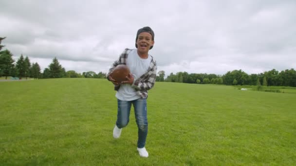 Emocionado chico negro en edad escolar celebrando touchdown en el campo — Vídeo de stock