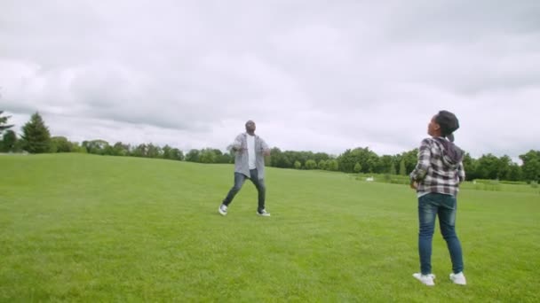 Θετικός μαύρος πατέρας και γιος που περνά το αμερικανικό ποδόσφαιρο σε εξωτερικούς χώρους — Αρχείο Βίντεο