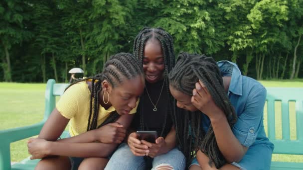 Gadis remaja african indah menonton konten media sosial online di telepon — Stok Video