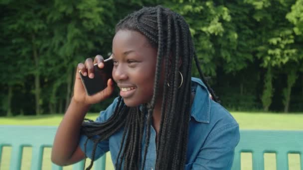 Adorable african teenage girl chatting on cellphone outdoors — Stock Video