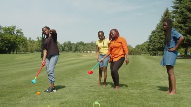Bekymmersfri afrikansk familj har roligt att spela krocket på park gräsmatta — Stockvideo