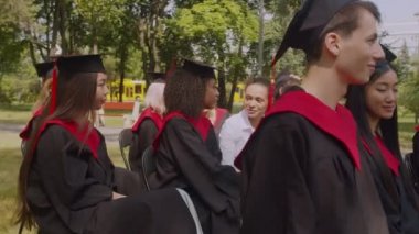 Güzel siyah öğrenci mezuniyet gününde bayan dekana dedikodu fısıldıyor.
