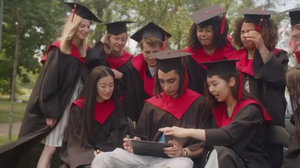 이번 졸업식에 참석 한 긍정적 인 다양 한 인종 학생들 이 태블릿 PC 로 웹 사이트를 운영하고 있다. — 비디오