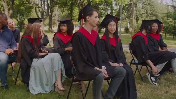 Různé multietnické studenty chatování během promoce ceremoniálu — Stock video