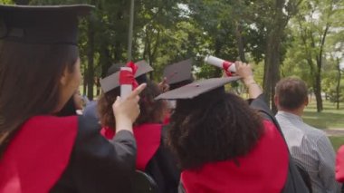 Mezuniyet töreninde selfie çeken çeşitli çok ırklı mezunlar.