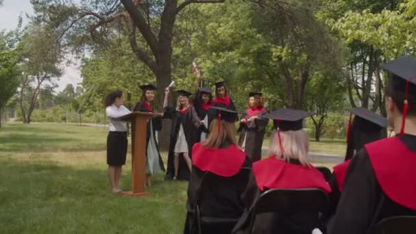 Unbekümmerte multiethnische Absolventen mit Diplomen tanzen am Abschlusstag — Stockvideo