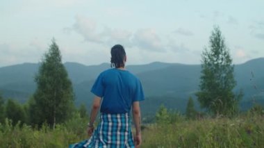 Neşeli gezgin çift, dağ tepesinde özgürlüğün ve eğlencenin tadını çıkarıyor.