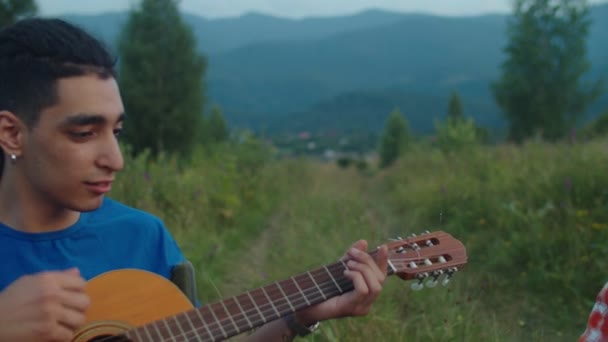 Όμορφοι hipster πολυεθνικοί άνδρες τουρίστες που παίζουν ακουστική κιθάρα και τύμπανο djembe στα βουνά — Αρχείο Βίντεο
