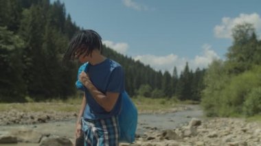 Çevre temizliğinden sonra çöp torbası taşıyan yakışıklı Arap erkek eylemci