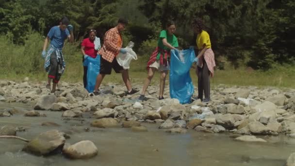 一群生态意识丰富的多族裔志愿者清理河岸垃圾 — 图库视频影像