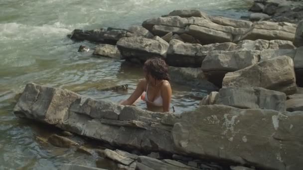 Elegante mujer afroamericana encantadora en traje de baño tomar el sol en el río de montaña — Vídeos de Stock