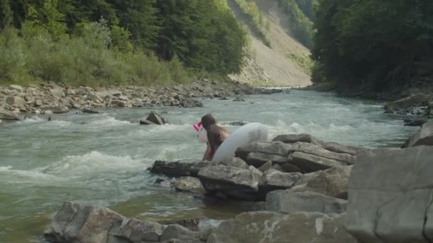 Очаровательная очаровательная азиатка в купальнике, весело плавающая на большом надувном кольце в горной реке — стоковое видео