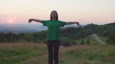 Esnek, oldukça sportif, Asyalı bir kadın güneş doğarken doğada esneklik gösteriyor.