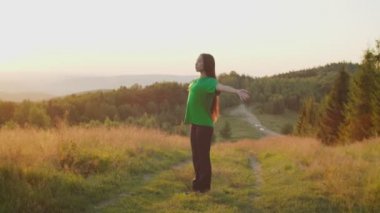 Sakin, güzel Asyalı kadın yoga duasında meditasyon yapıyor. Gün doğumunda dağın tepesinde poz veriyor.