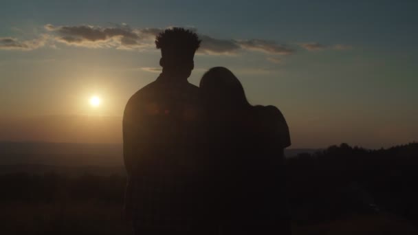 Silhouette ζευγάρι στέκεται στην αγκαλιά της αγάπης, απολαμβάνοντας γραφική ορεινή φύση κατά τη δύση του ηλίου — Αρχείο Βίντεο