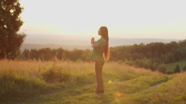 Lugn härlig asiatisk kvinna med slutna ögon mediterar i bön yoga pose på bergstopp i gryningen — Stockvideo