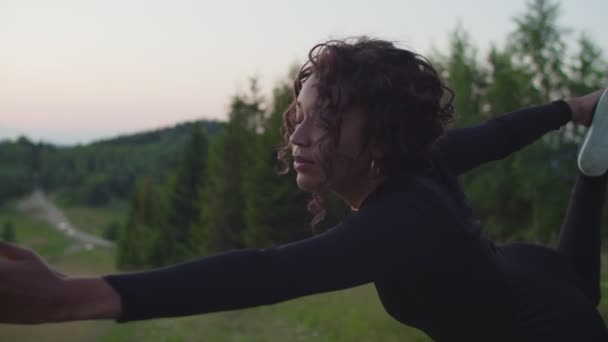 Портрет активной спортивной физической формы черной женщины, практикующей йогу растяжку в горах на восходе солнца — стоковое видео