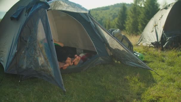 A piedi nudi backpackers femminili multirazziali rilassarsi in tenda da campeggio su escursioni in montagna — Video Stock