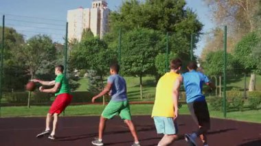 Heyecanlı sportif formda, çok ırklı erkek basketbolcular turnike atışlarıyla puan topluyor, galibiyeti göğüs tokuşturarak ve dışarıda sahanın ortasında sokak oyunu oynarken beşlik çakarak kutluyorlar..
