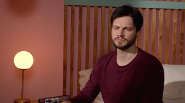 Pijamalı, düşünceli, yakışıklı, sakallı bir adamın portresi. Rahat bir yatakta oturup, sabah erkenden yatak odasında uyandıktan sonra sorunlarını ve kararlarını düşünüyor..