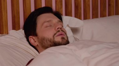 Sakallı, sakallı, sakallı, orta yaşlı bir adamın portresi tıkanmış uyku apnesinden muzdarip, yatakta mışıl mışıl uyuyor ve geceleri yatak odasında dinlenirken yüksek sesle horluyor..