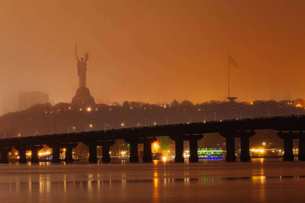 Paton Bridge at Night in Autumn, Kyiv, Ukraine. Night view of the historic Paton Bridge illuminated over the Dnipro River in Kyiv, Ukraine, during the autumn season.
