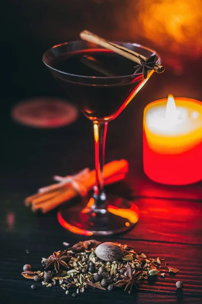 Baharatlı kırmızı içecek glintwein, tarçın, anason, meyve, esmer şeker eski ahşap bir masa üzerinde. Yeni yıl ve Noel tatili konsepti. Sıcak şarap ve glintwein.