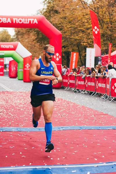 POLTAVA, UKRAINE - 1 Eylül 2019: Nova Poshta Poltava Yarı Maratonu sırasında şık bir adam bitiş çizgisine ulaştı