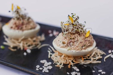 Çırpılmış yumurta, doldurulmuş yumurta füme jambon, mayonez, yumurta sarısı ve taze mikroyeşilden yapılmış bir macunla doldurulmuş. Lezzetli Paskalya kahvaltısı, parti ya da tatil yemekleri için aperatif..