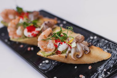 Taze salata, yumurta, yeşillik, karides, ahtapot soslu deniz ürünleri bruschetta ekmeği..