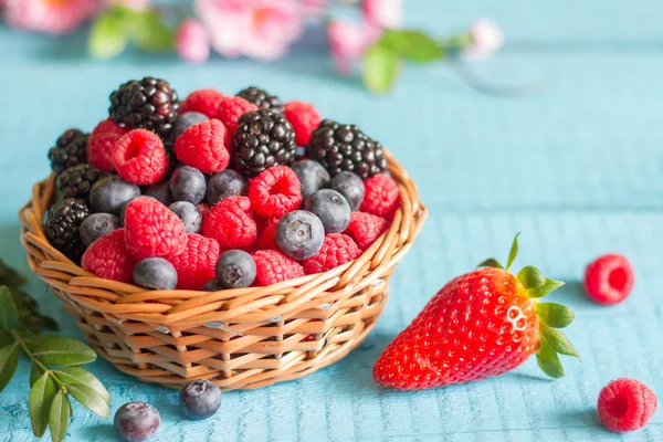 Berries spring fruits on blue wooden boards abstract still life — Stock Photo, Image