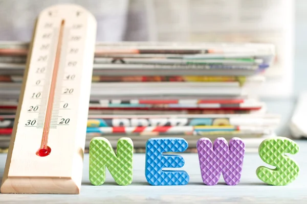 Heiße Nachrichten kreatives Symbol mit Thermometer und Zeitung — Stockfoto