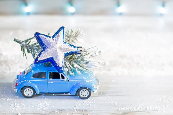Boże Narodzenie zbliża się streszczenie gwiazda jodła i samochód na tle niebieski niewyraźne — Zdjęcie stockowe