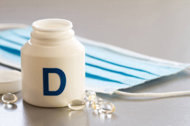 Kapsüllerde D vitamini ve tıbbi maske. Coronavirus, dokunulmazlık destek kavramı