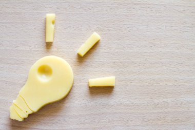 Yemek fikri, kesme tahtasındaki peynirden yapılmış ampul. 