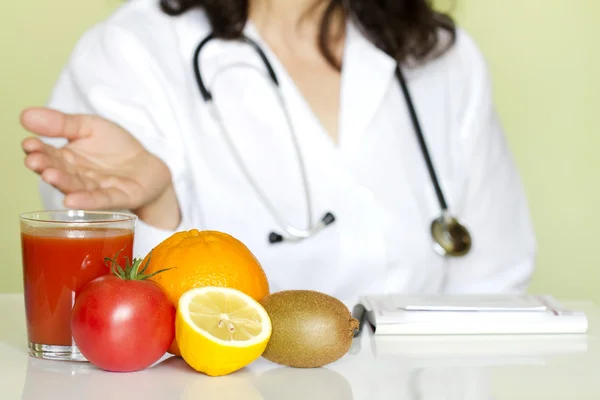 Läkare nutritionist i office med friska frukter kost koncept Stockbild