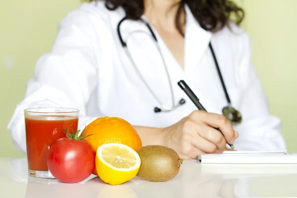 Läkare nutritionist i office med friska frukter kost koncept Royaltyfria Stockfoton