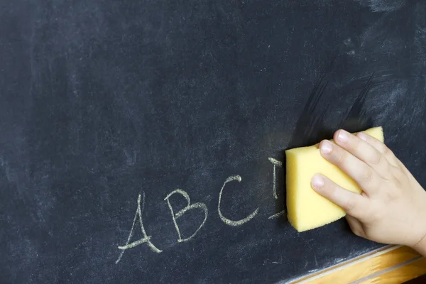 Child hand cleans letters abc education background concept — Stock Photo, Image
