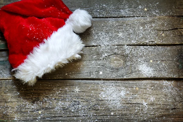 Шляпа Санта-Клауса на старинных деревянных досках рождественский фон — стоковое фото
