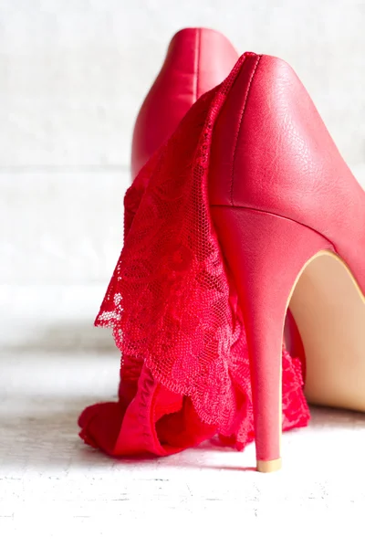 High heels and red g-string abstract concept on white boards — Stock Photo, Image