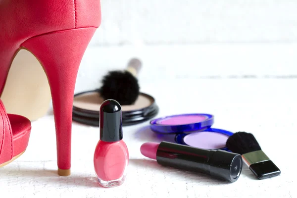 Tacones rojos altos y conjunto de cosméticos abstractos sobre tablones blancos — Foto de Stock