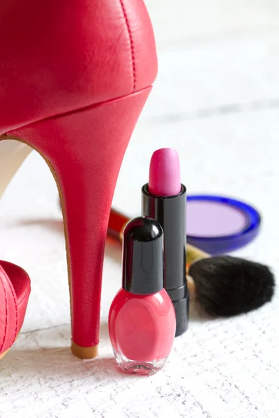 High red heels and set of cosmetics abstract on white planks — Stock Photo, Image