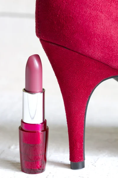 Tacones rojos altos y conjunto de cosméticos abstractos sobre tablones blancos — Foto de Stock