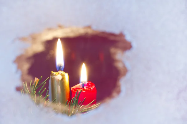 Christmas candles on a snowy window concept — Stock Photo, Image