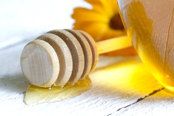 Tarro de miel primer plano sobre tablones blancos — Foto de Stock