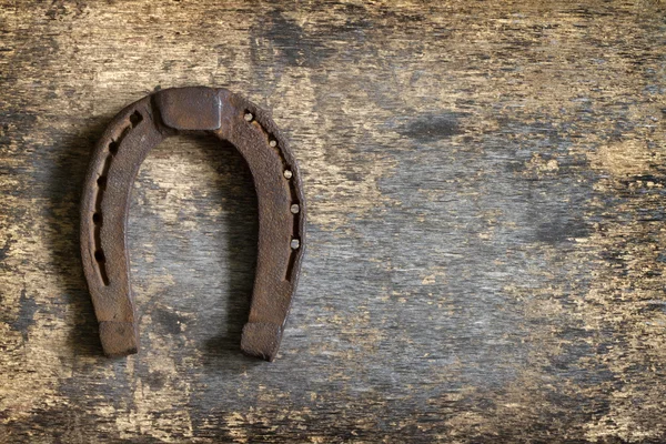 Vecchio ferro di cavallo arrugginito su tavola vintage sfondo astratto — Foto Stock