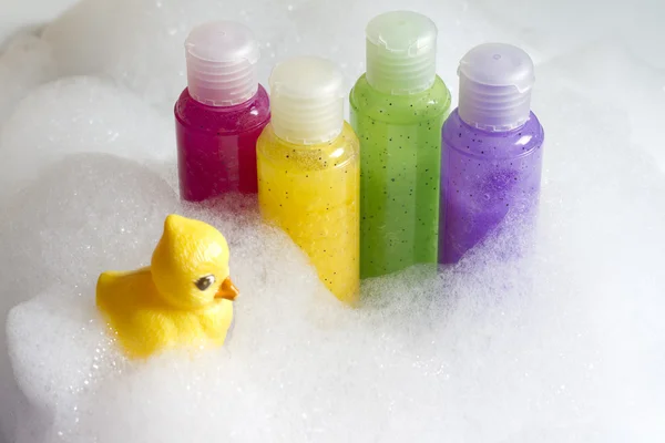 Cosméticos coloridos jabones en el baño en espuma abstracta —  Fotos de Stock